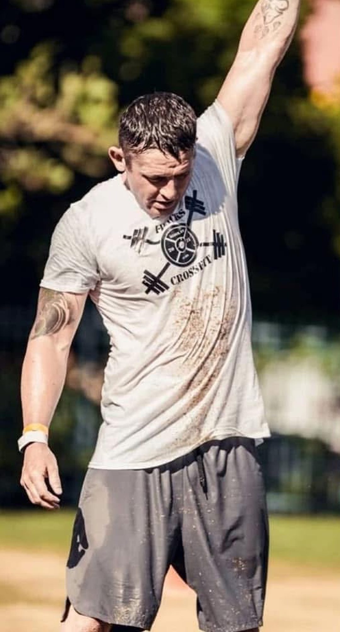 Ty McMillan raising one arm overhead at an outdoor fitness event